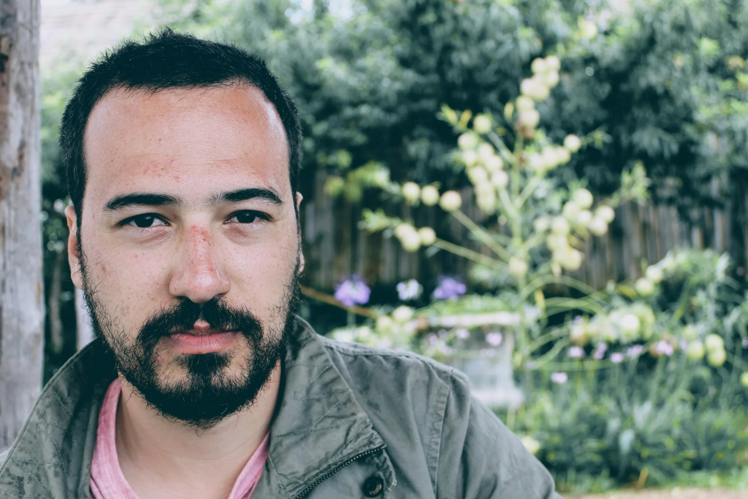 pexels-photo-713520-713520 Portrait of a young man with facial hair, outdoors in a natural setting. Serious expression.